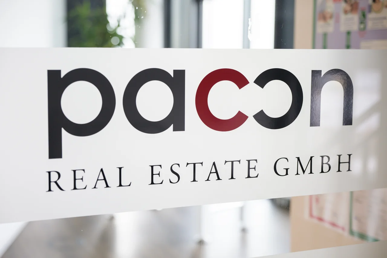 Schriftzug „pacon Real Estate GmbH" an einer Glastür im Büro